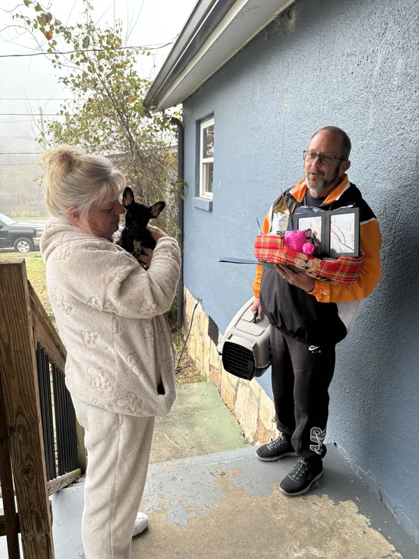 A family holding their First Pick puppy outside a home